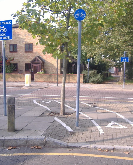 1st sign tells cyclists to look both ways before a cycle path heads though a tree. 2nd sign tells cyclists to look left as they cross a two-way street. 3rd sign tells cyclists to keep left - through a bush